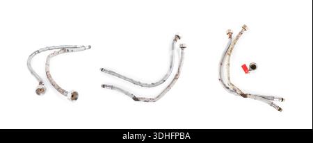 Old rusty flexible water hoses and valve isolated on white. Set of worn, corroded braided metal plumbing pipes showing damage and decay for repair con Stock Photo