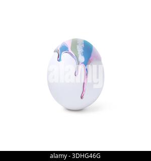 Colorful paint dripping down egg on white background. Easter celebration Stock Photo