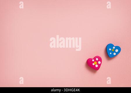 A minimalist photo featuring two small heart-shaped decorations on a soft pink background, creating a sweet and romantic mood. For greeting cards Stock Photo