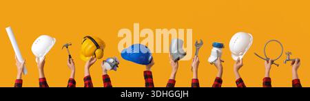 Many hands with hardhats and construction tools on yellow background Stock Photo