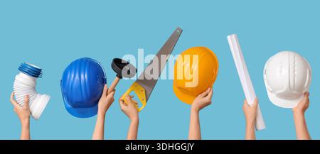 Hands with hardhats and construction tools on blue background Stock Photo