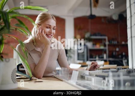 Caucasian Young Adult Woman Smiling While Working on Architectural Model Stock Photo