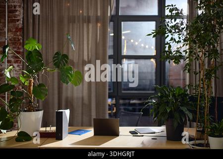 Modern Office Desk Featuring Laptop and Smartphone near Large Window Stock Photo