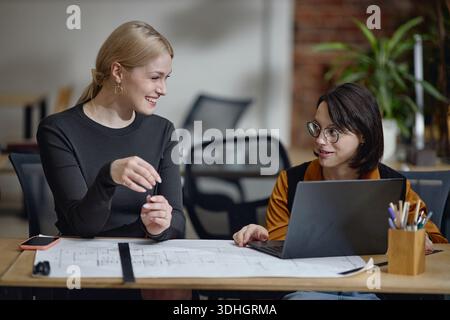 Young Woman with Disability Working with Colleague on Architectural Project Stock Photo