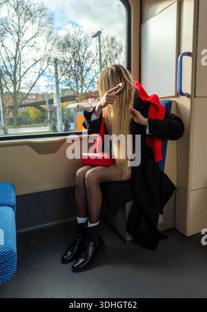 Woman combing her hair while traveling by bus on a sunny day Stock Photo