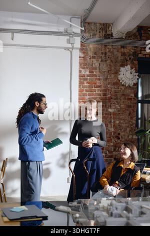 Multiethnic Young Adults Collaborating during Informal Office Meeting Stock Photo