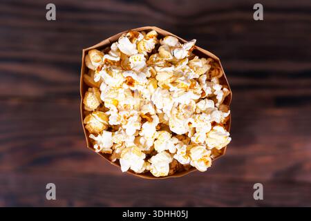 Popcorn in paper container on wooden background Stock Photo
