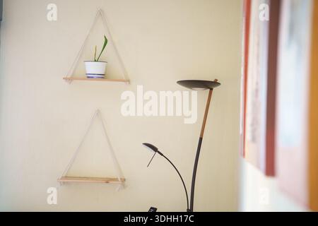 Minimalist cozy workspace, Elegant studio setup featuring hanging shelves and natural illumination Stock Photo