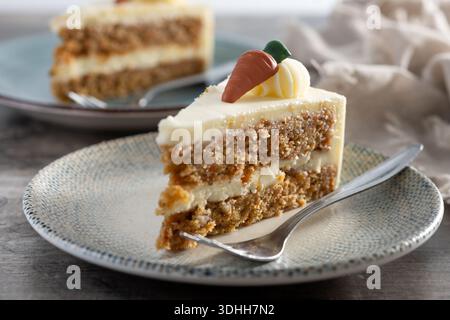Carrot cake slice with cream cheese frosting on wooden table Stock Photo