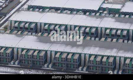 Aerial view of the vast, snow-dusted data center, its metallic structures contrasting sharply with the stark white landscape, Middenmeer, North Hollan Stock Photo