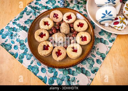 Christmas Linzer cookie and nut on plate, napkin and Christmas ball on plate on wooden table, closeup. Stock Photo