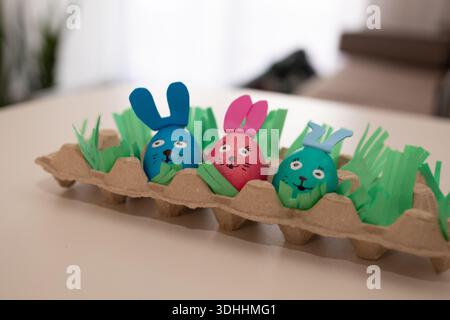 A colorful group of decorated Easter bunny eggs in an egg carton, with lovely grass adding a festive touch Stock Photo