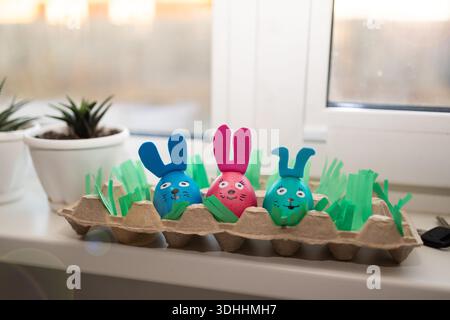 Whimsical and playful Easter decorations featuring beautifully painted bunny eggs nestled in an egg carton Stock Photo