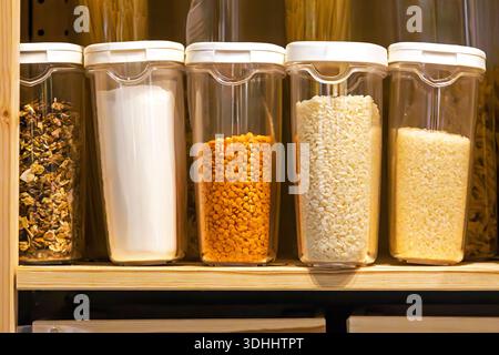 Plastic containers full of groceries on shelf storage pantry at home interior Stock Photo