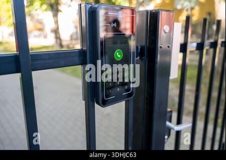 Smart intercom with face recognition is installed on gate leading to home territory. Modern access control system emphasizes security automation and s Stock Photo