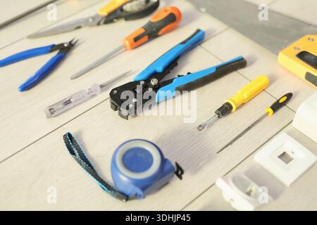 Workstation filled with various hand tools for DIY projects and crafts in a bright workspace during the day Stock Photo