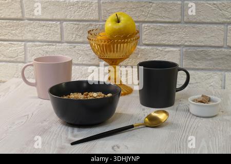 Muesli and two cups of coffee for breakfast on the table Stock Photo