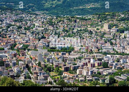 Aerial view of a cityscape of Lugano in canton Ticino, Switzerland, with a mix of modern and traditional buildings, surrounded by green hills Stock Photo