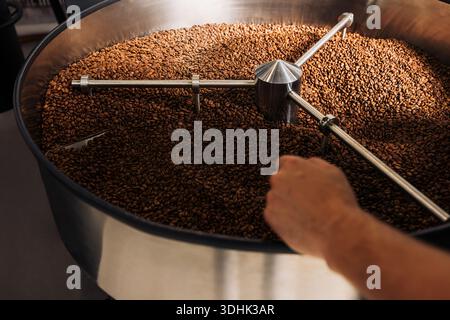 The cooling drum of industrial roasting coffee machine. Roasted beans cooling in the drum after roasting. Stock Photo
