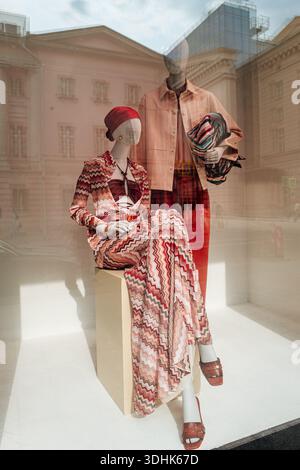 Male and female mannequins dressed in stylish summer clothing in the window display of a luxury fashion boutique. Stock Photo
