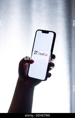 Kaliningrad, Russia - 12.11.2025. Woman holds smartphone showing CapCut logo on screen. Video edit Stock Photo