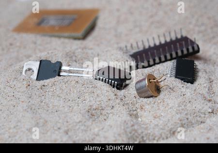 Semiconductor components made of silicon on the sea sand. CPU, integrated circuits and transistors. Stock Photo