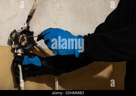 Close-up of electrician working on electrical connection inside a junction box using a screwdriver. Concept of electrical installation, maintenance wo Stock Photo