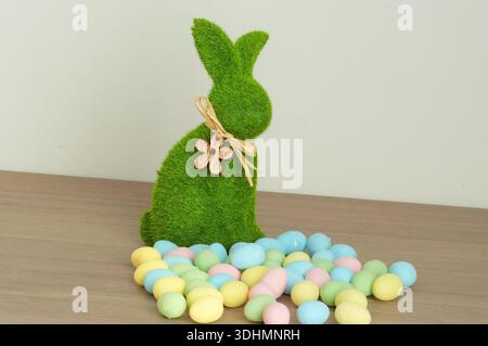 Easter bunny with colorful eggs on wooden table. Easter decoration. Stock Photo