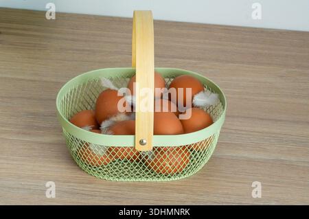Eggs in basket on wooden table. Close-up. Stock Photo