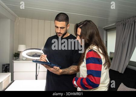 Man and woman collaborating on digital tablet with stylus Stock Photo