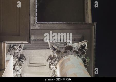 Intricate stone carving on architectural pillar showing leaf patterns under subtle illumination from below Stock Photo