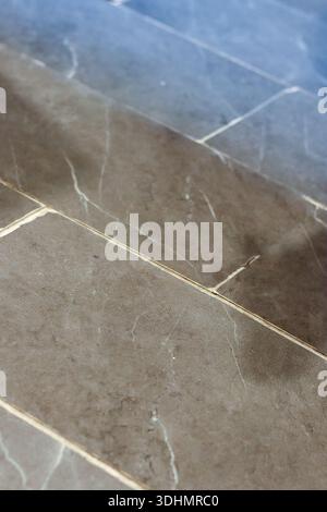 Textured gray stone tiles with white veins arranged in diagonal pattern on floor surface Stock Photo