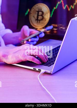 Typing on keyboard with bitcoin symbol and chart overlay, depicting online financial activity. Stock Photo