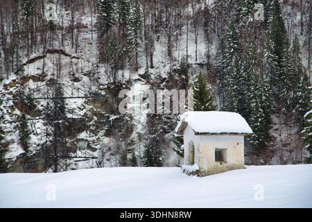 A snowy landscape in Montafon, Austria featuring a quaint house surrounded by winter trees. Stock Photo