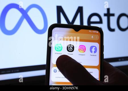 Auf einem Smartphone sind die Apps von Threads, Instagram, WhatsApp und Facebook zu sehen. Dahinter wurde auf einem Laptop das Logo des Betreibers Meta Platforms aufgerufen. Symbolbild/Symbolfoto. Schnelsen Hamburg *** The apps from Threads, Instagram, WhatsApp and Facebook can be seen on a smartphone Behind it, the logo of the operator Meta Platforms was called up on a laptop Symbol image Symbol photo Schnelsen Hamburg Stock Photo