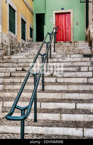 A small set of steps leads to a red door in the Alfama district of Lisbon, Portugal. Stock Photo