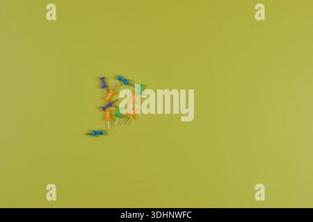 Colorful push pins on yellow-green surface highlight organization, planning, and visual contrast in office or educational settings. Stock Photo