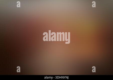 A smooth, out-of-focus abstract background featuring a warm gradient of brown, tan, and dark red tones, creating a soft bokeh effect. Stock Photo