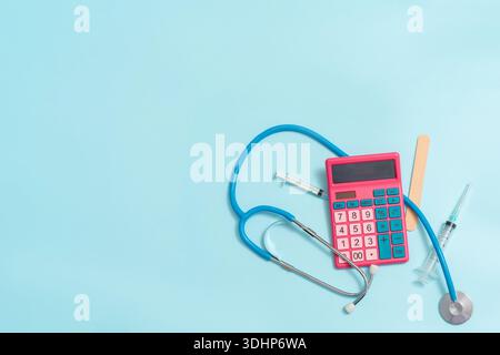 A calculator with medical instruments and a stethoscope on a blue background, a place for text, the concept of the cost of medical services Stock Photo