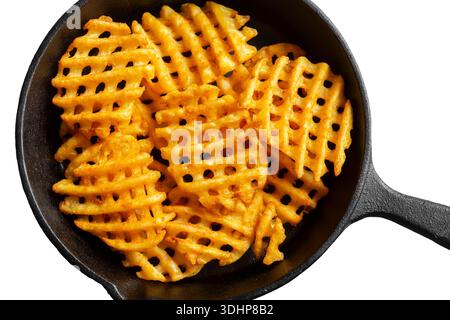 Waffle criss cross fries in a cast iron frying pan isolated on a white background. Unhealthy fast food concept Stock Photo