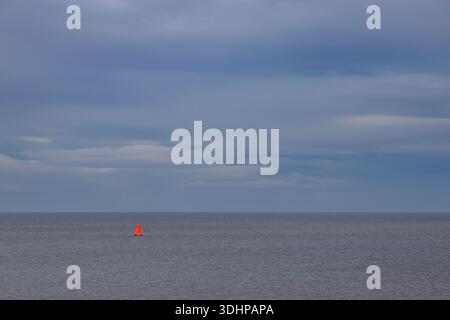 Red navigation buoy isolated against sea and sky at Crosby Stock Photo