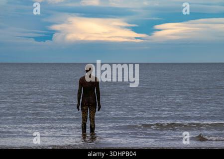 Figure from Antony Gormley’s Another Place installation standing in the sea at Crosby Stock Photo