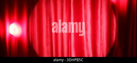 Shining spotlight on red curtain Stock Photo