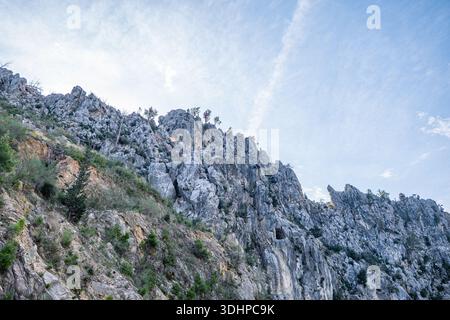 Detailed texture shot of a steep, rugged limestone mountain face with sparse vegetation in the Taurus Mountains, Turkey. Stock Photo