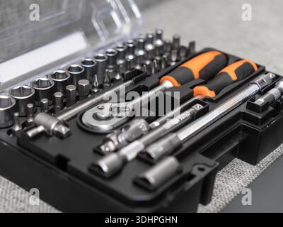 Close-up of a neatly organized black plastic tool case, containing a wide range of metal sockets, bits, and ratchet wrenches for versatile repair appl Stock Photo