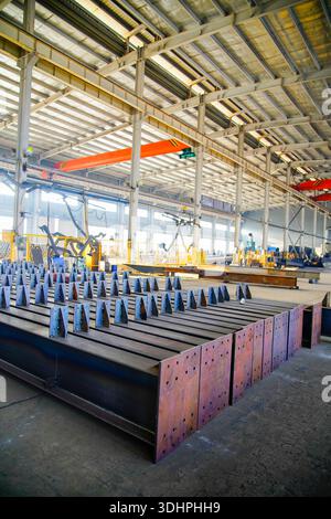 Steel structure processing in heavy industry factory, production line of metal components in factory building. Stock Photo