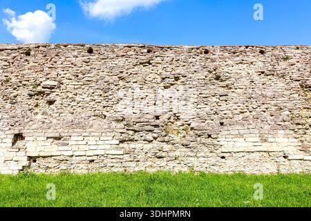 Rough stone wall of the ancient medieval fortress Izborsk in summer Stock Photo
