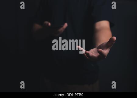 Male empty hand open a palm up on a dark background. Stock Photo