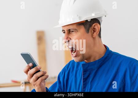 Construction worker screaming, angry and phone with man  for communication, frustrated and connection. Bad news, problem and corporate with male for d Stock Photo