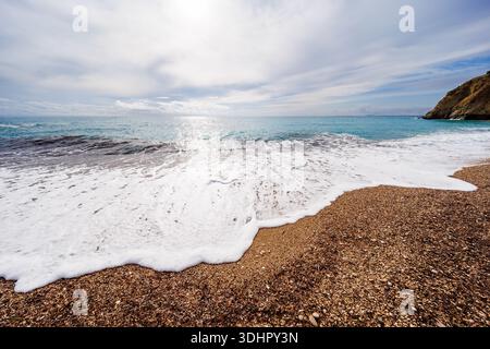 Soft Foam Edge on Pebble Shore Stock Photo